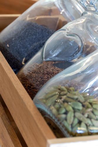 a glass bottle filled with brown beans in a wooden tray at Hotel Campagnola in Riva del Garda
