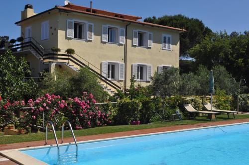 una casa y una piscina frente a una casa en Hotel Tirrena Bike & Country Hotel, en Portoferraio