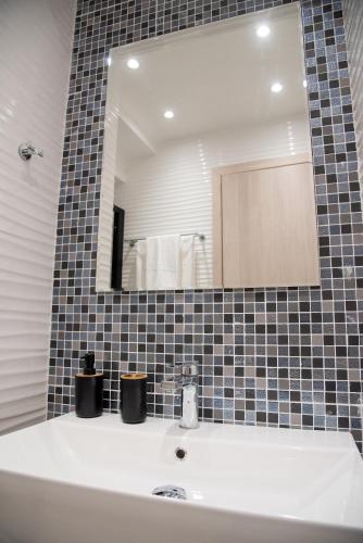 a bathroom with a sink and a mirror at Chrysanthi's Apartment in Preveza