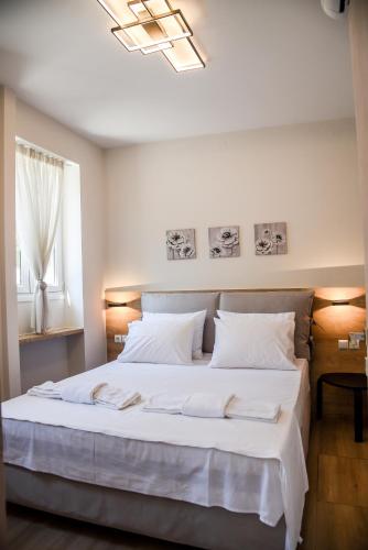 a bedroom with a large white bed with a window at Chrysanthi's Apartment in Preveza