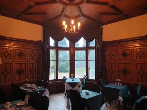 a dining room with two tables and a chandelier at Fieldways in Trowbridge