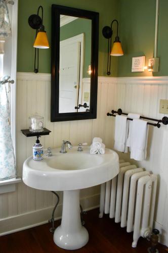 a bathroom with a sink and a mirror and towels at Harbour House Inn B&B in Cheshire