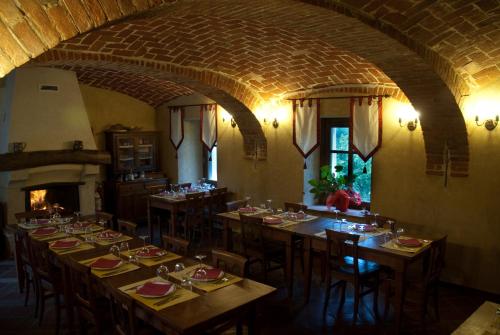 a dining room with tables and chairs and a fireplace at La Corte del Barbio in Aramengo