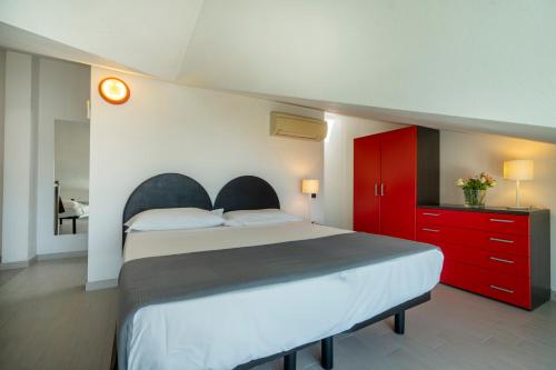 a bedroom with a large bed and red cabinets at Hotel Cristallo in Rimini