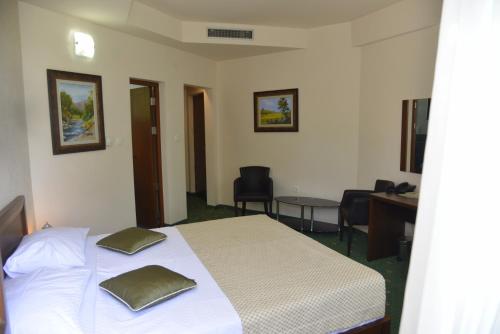a bedroom with a bed with two pillows on it at Hotel Trebjesa in Nikšić