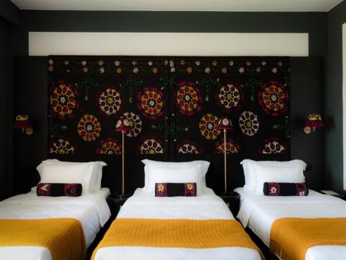 two beds in a room with black walls at Esquisse Design Hotel in Tʼelavi