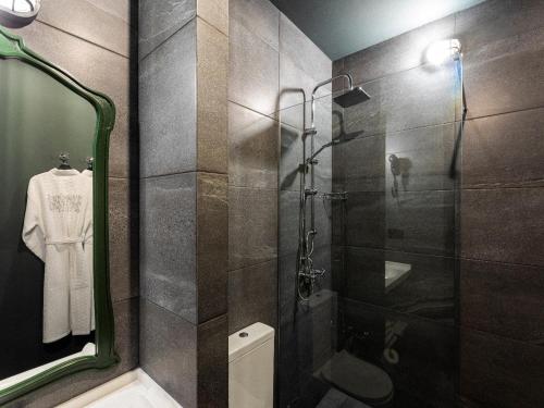 a bathroom with a shower and a toilet and a mirror at Esquisse Design Hotel in Tʼelavi