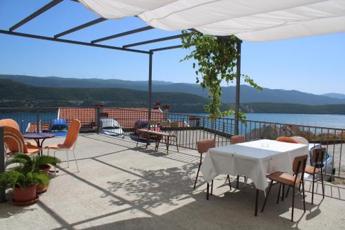 a patio with tables and chairs and a view of the water at Apartments Kata in Neum