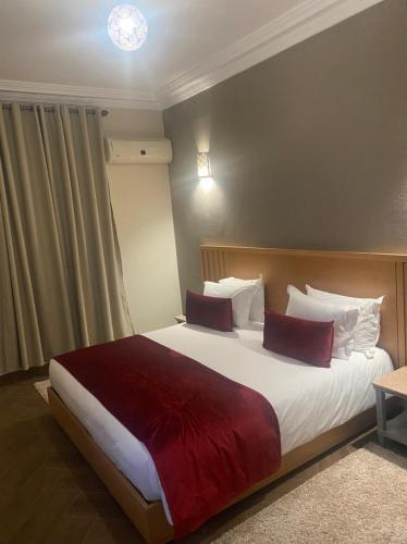 a bedroom with a large bed with a red blanket at Golden Beach Appart'hotel in Agadir