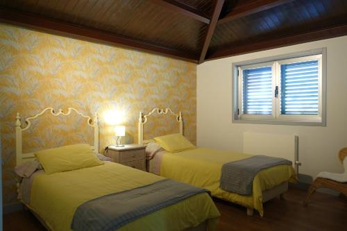 sypialnia z dwoma łóżkami i oknem w obiekcie Batán - Preciosa casa en el Valle del Salnés w mieście Pontevedra