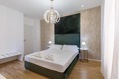 ein Schlafzimmer mit einem großen Bett und einem Kronleuchter in der Unterkunft ALMi in Cagliari