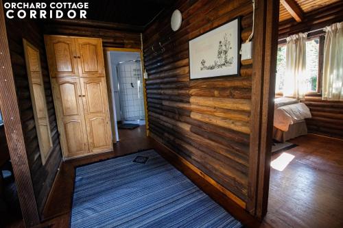 a room with wooden walls and a bedroom with a bed at JAYA'S PLACE in Hogsback