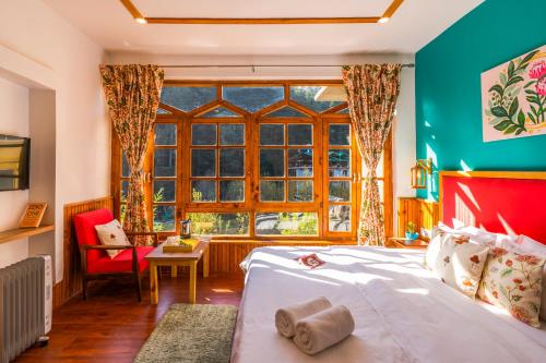 a bedroom with a bed and a large window at Zen Manali by Keekoo Stays in Manāli