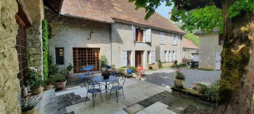 an outdoor patio with a table and chairs in a building at Les Vagabonds du Mont in Chichilianne