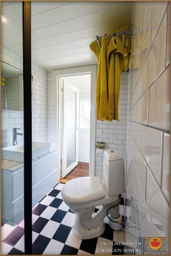 a bathroom with a toilet and a sink and a mirror at Hem till Bengt in Kungshamn