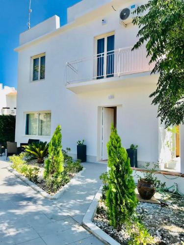 a white house with trees in front of it at B&B Villa Dunardi in Fontane Bianche