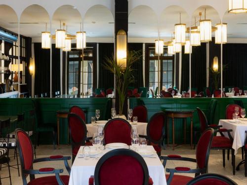 a dining room with tables and chairs and chandeliers at Esquisse Design Hotel in Tʼelavi