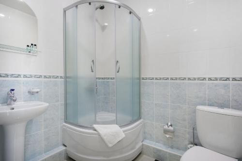 a bathroom with a shower and a toilet and a sink at Business Hotel Rodina in Essentuki