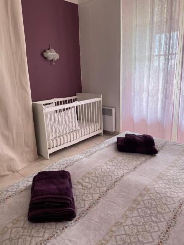 - une chambre avec un lit bébé et 2 serviettes dans l'établissement LA BASTIDE DE CHARME, à Vence
