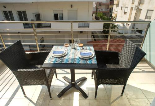 a table and chairs on a balcony with a table and glasses at Lux VIP Apartments in Perea