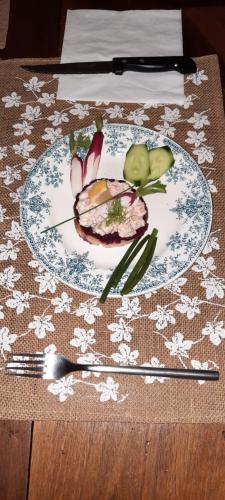 a plate with meat and vegetables on a table at Les Vagabonds du Mont in Chichilianne