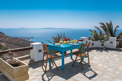 un tavolo blu con sedie su un patio con vista sull'oceano di Fanari sea view studios a Fanari