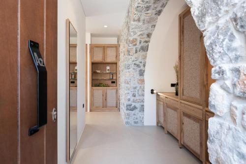 a hallway with a stone wall and a door at The Authentic Village Boutique Hotel in Khóra Sfakíon