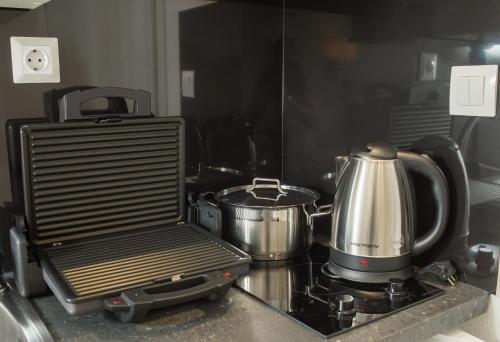 a kitchen counter with a stove with pots and pans at Lux VIP Apartments in Perea
