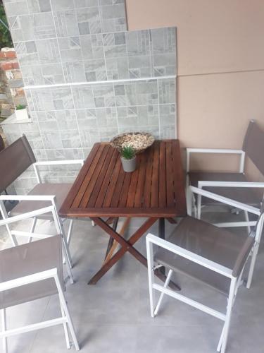 a wooden table with chairs and a potted plant on it at Violetta Studios & Apartments in Milína