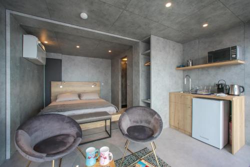 - une chambre avec un lit et deux chaises dans l'établissement Cabane CASSIOPEE Aigues- Mortes, à Aigues-Mortes