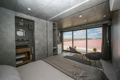 a bedroom with a bed and a view of the ocean at Cabane CASSIOPEE Aigues- Mortes in Aigues-Mortes