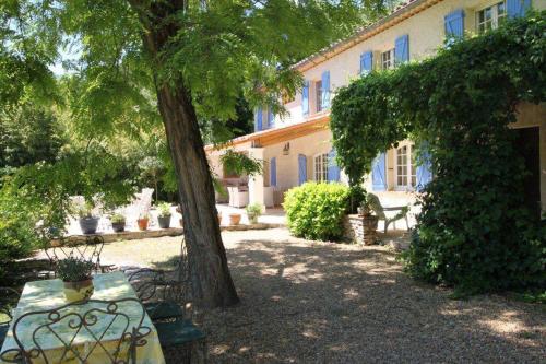 a bench sitting under a tree in front of a building at bastide derroc in Cotignac