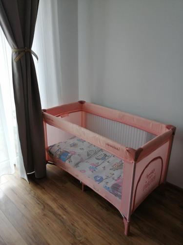 a pink crib bed in a room with a window at Art House in Floreşti