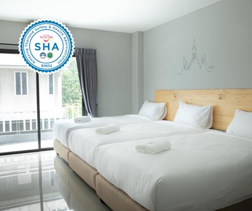 two beds in a room with a sign that says sla at Fine Bed Hotel in Nonthaburi