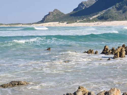 a beach with some rocks in the water at Just Chill Betty's Bay in Bettyʼs Bay