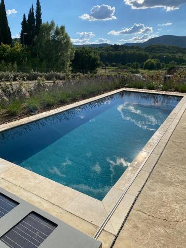 une piscine avec de l'eau bleue dans une cour arrière dans l'établissement Les Palivettes 2.1, à Malaucène