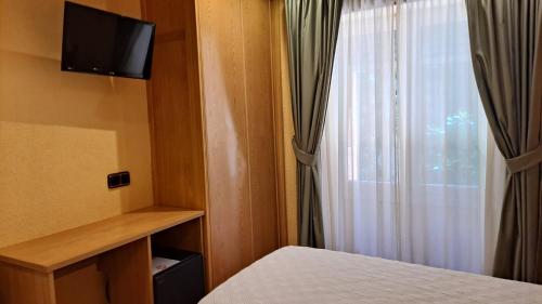 Kleines Zimmer mit einem Bett und einem Fenster in der Unterkunft Pensión La Concha in San Sebastián