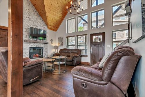 sala de estar con muebles de cuero y chimenea en Rockwood Lake Lodge home, en Branson