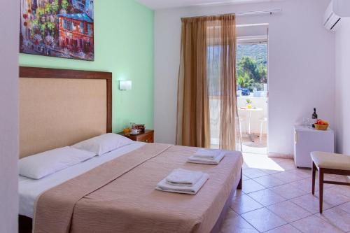 a bedroom with a large bed with two towels on it at Xidas Garden in Balíon