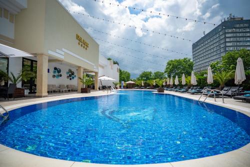 a large blue swimming pool in front of a building at Hotel Del Mar & Conference Center in Mamaia