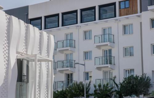 a white building with balconies on the side of it at Amazing Maisonette next to harbour of Paphos CY in Paphos