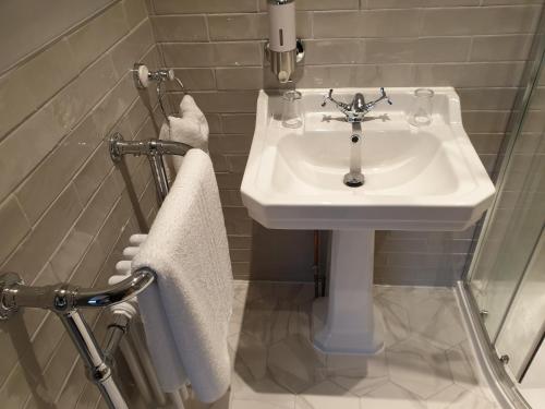 a bathroom with a white sink and towels at The Strutt Arms in Belper