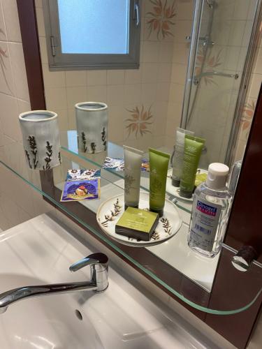 La salle de bains est pourvue d'un lavabo et d'un comptoir en verre avec un miroir. dans l'établissement Charmant appartement au cœur du village, à Tourrettes-sur-Loup