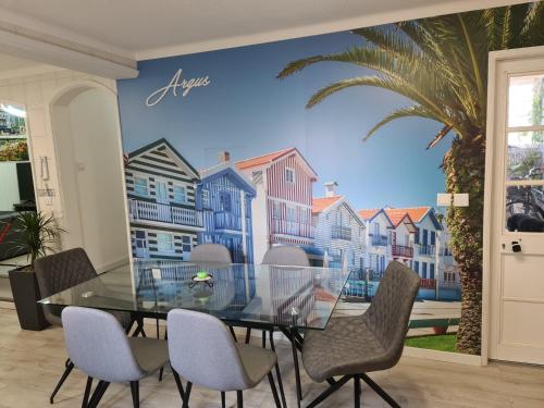 a dining room with a glass table and chairs at Argus Dream Home in Costa Nova