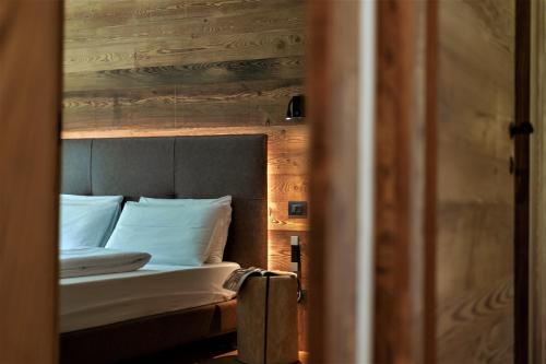 a bed with white sheets and pillows in a room at Orobie Alps Resort in Roncobello