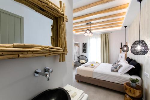 1 dormitorio con cama y espejo en la pared en LEMONIA STUDIOS&SUITES en Agia Anna Naxos