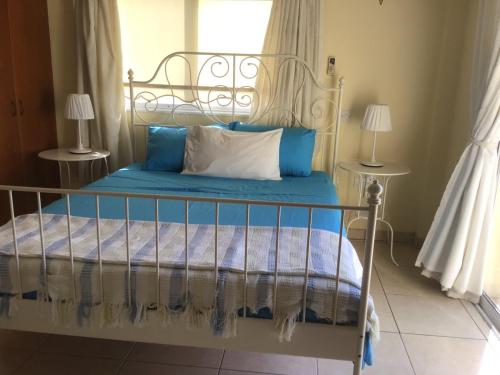 1 dormitorio con 1 cama con almohadas azules y blancas en Carolyn Villa, en Ayia Napa