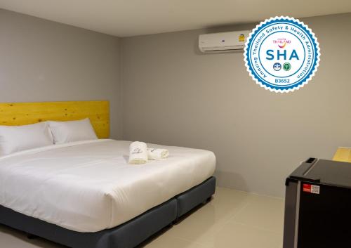 a bedroom with a bed and a sign that says sla at Fine Bed Hotel in Nonthaburi