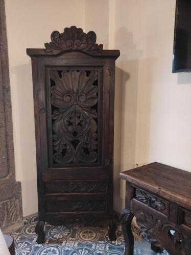 a wooden cabinet next to a table in a room at Nunõ in San Miguel de Allende