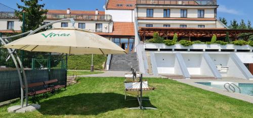 aige umbrella sitting in the grass next to a building at Hotel Berounka in Hřebečníky